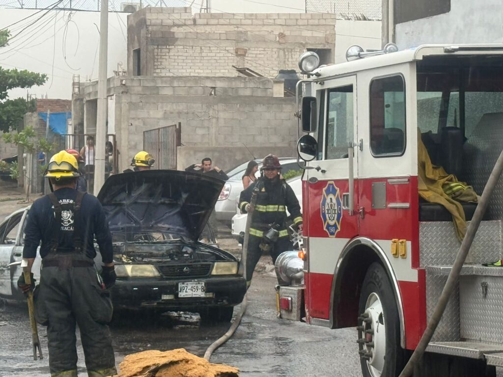Bomberos combatiendo el incendio del vehículo.