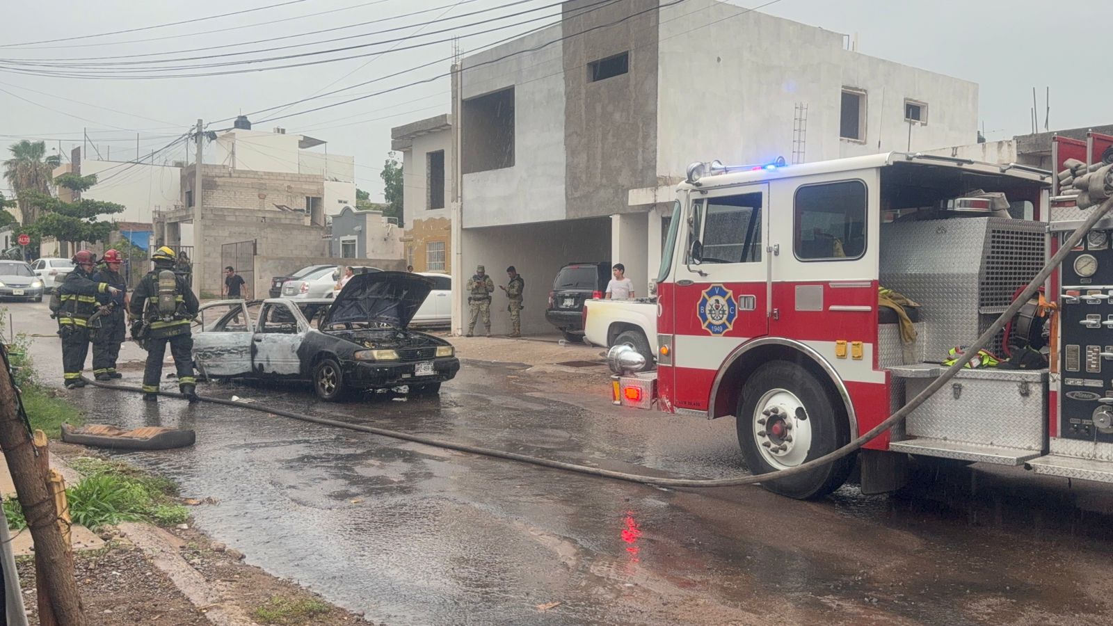 Bomberos presentes en el lugar donde se incendió el vehículo.