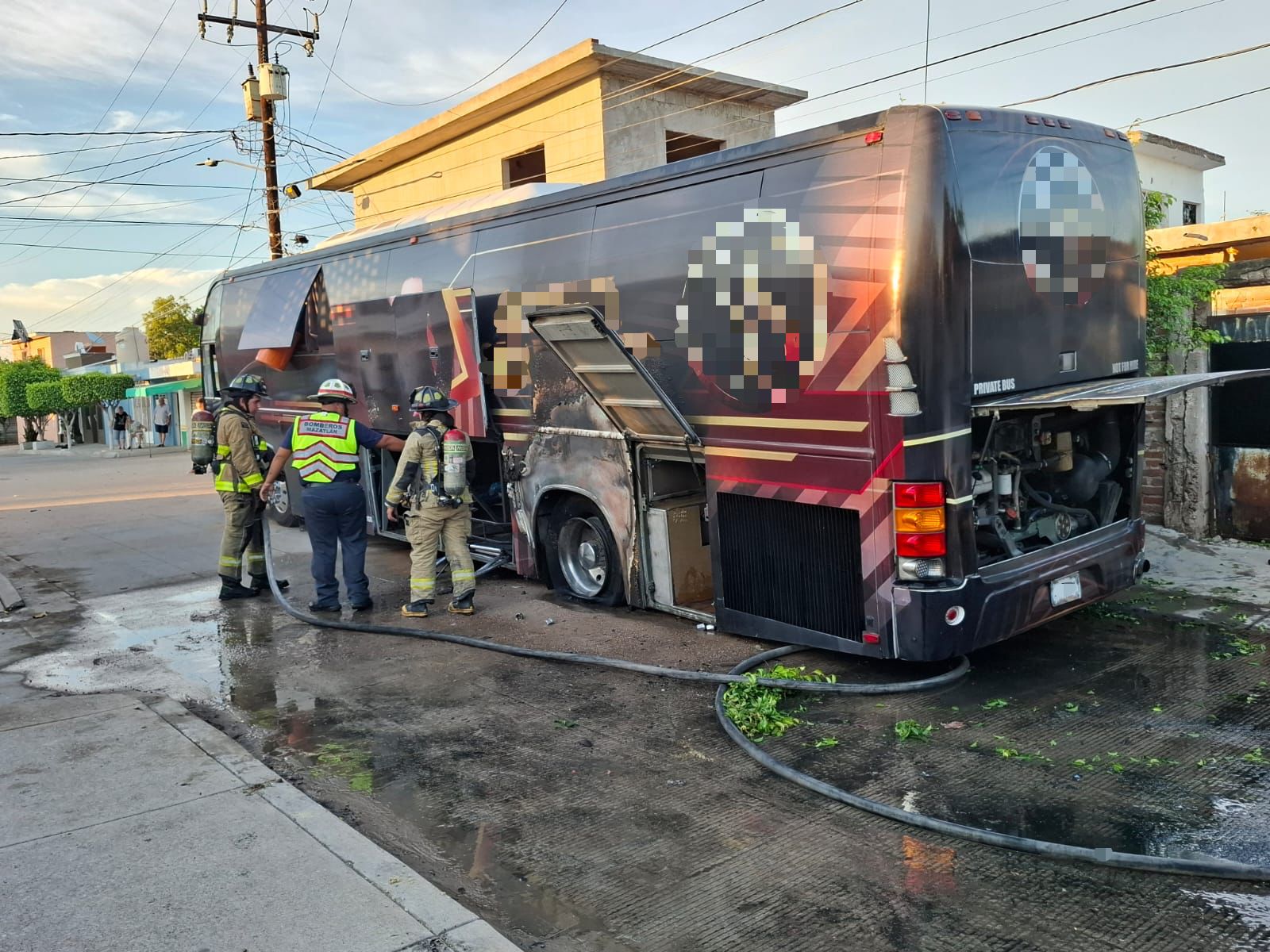 Bomberos atendiendo el fuego que ocasionó el papalote en el autobús.