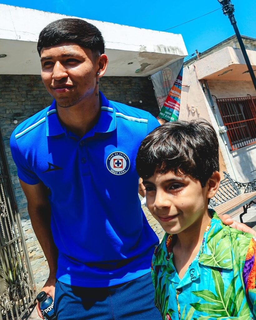Jaziel Mendoza tomándose foto con un pequeño aficionado.