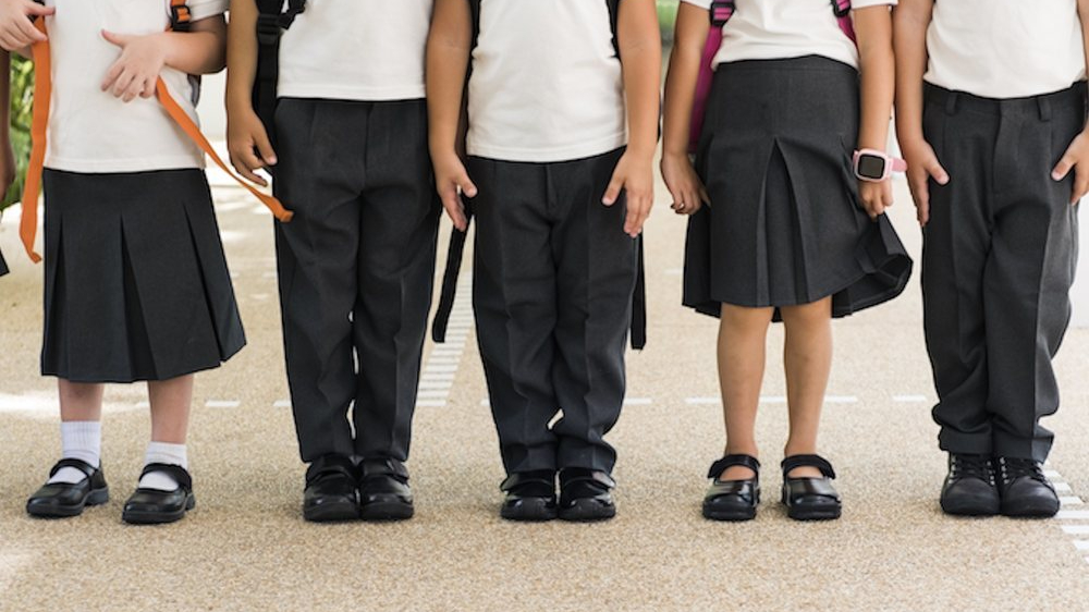 Niños portando el uniforme escolar.