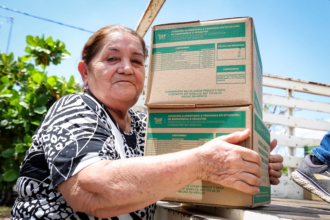 Mujer adulta recibiendo despensas alimentarias por parte del Sistema DIF Sinaloa.