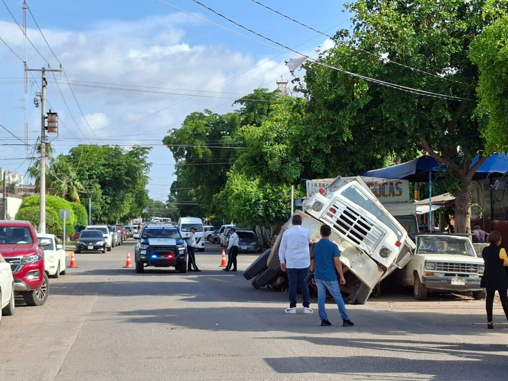Autoridades en el lugar donde se encuentra el dompe atorado en el socavón.
