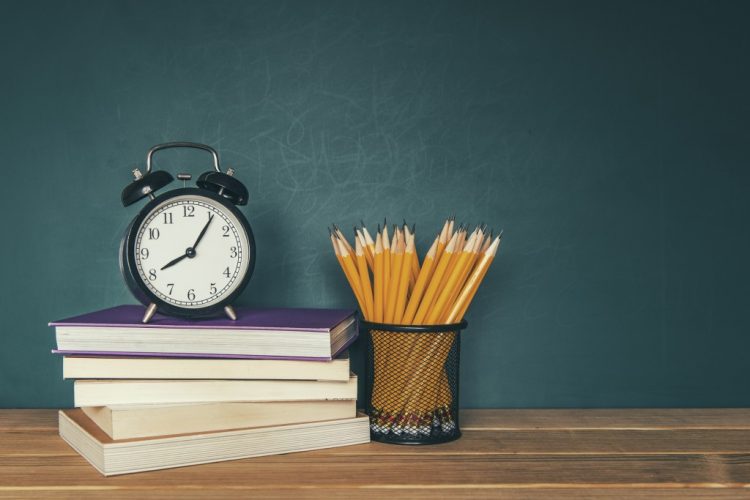 Libros, lápices y un reloj.