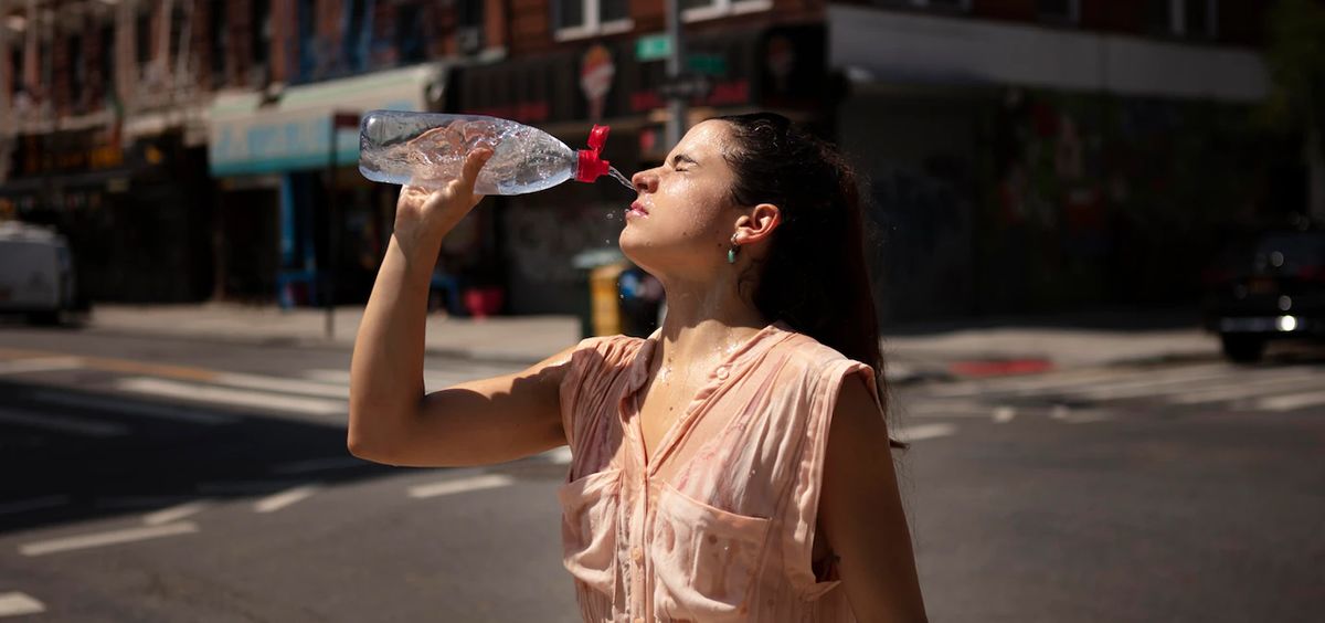 persona tomando agua en una calle