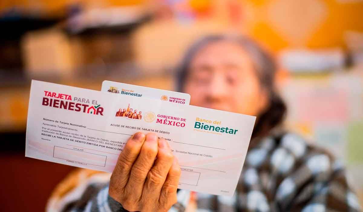 adulta mayor sostiene un sobre con su tarjeta de pensión bienestar