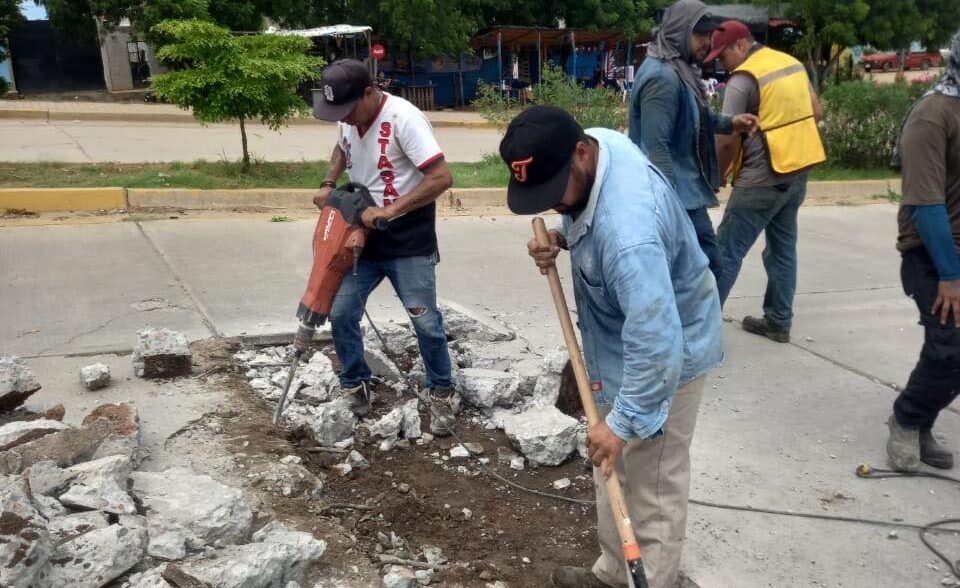 Personas trabajando en bache en calle de Mazatlán