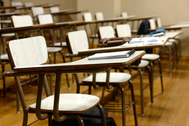 Salón de clases en escuela con mesabancos o butacas vacíos