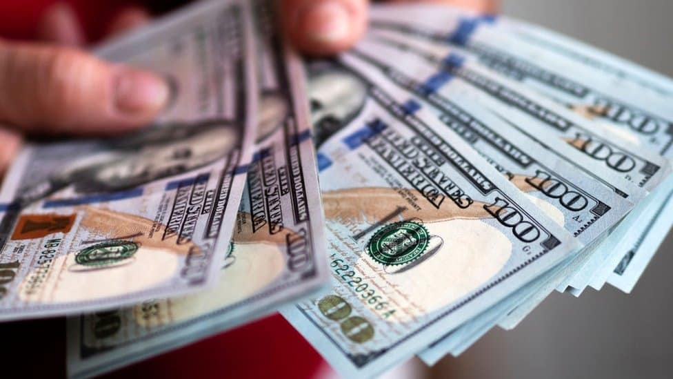 Billetes de dólar en una mano