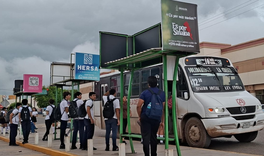 Jóvenes se suben a un camión de transporte público