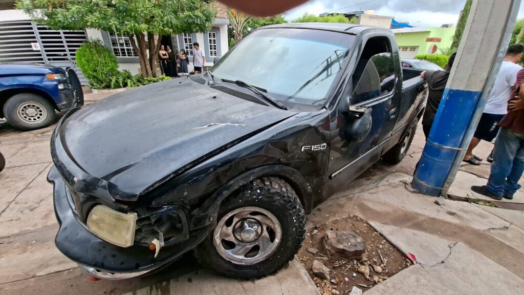Ford F150 de color negro con daños en la carrocería.