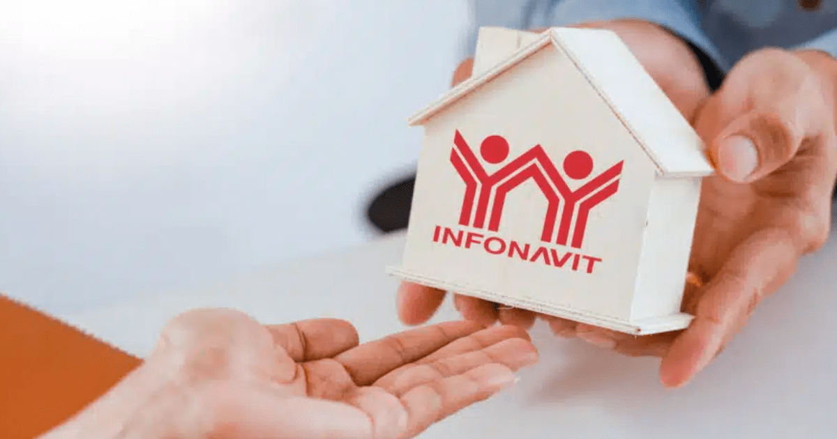 Manos tomando una casa de crédito Infonavit.