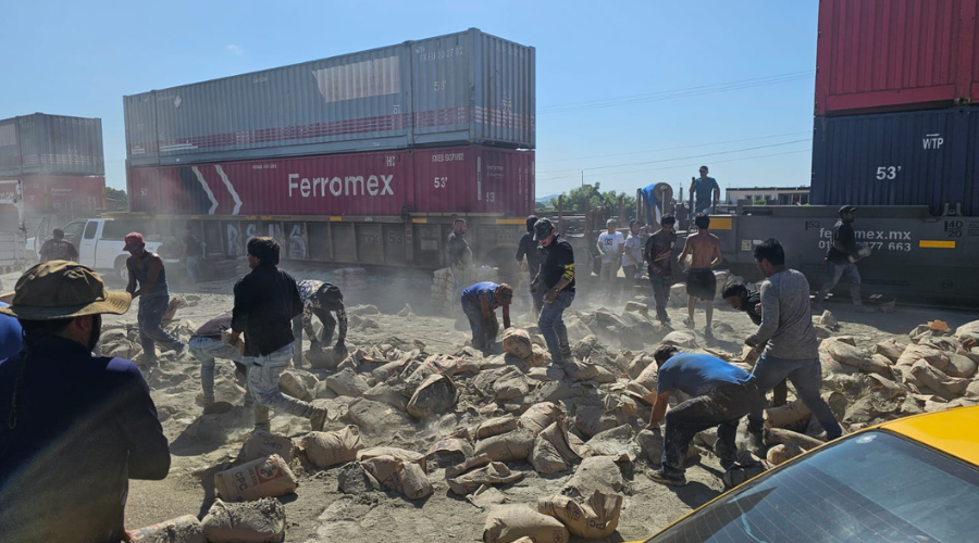 Personas levantan sacos de cemento tras la embestida del tren