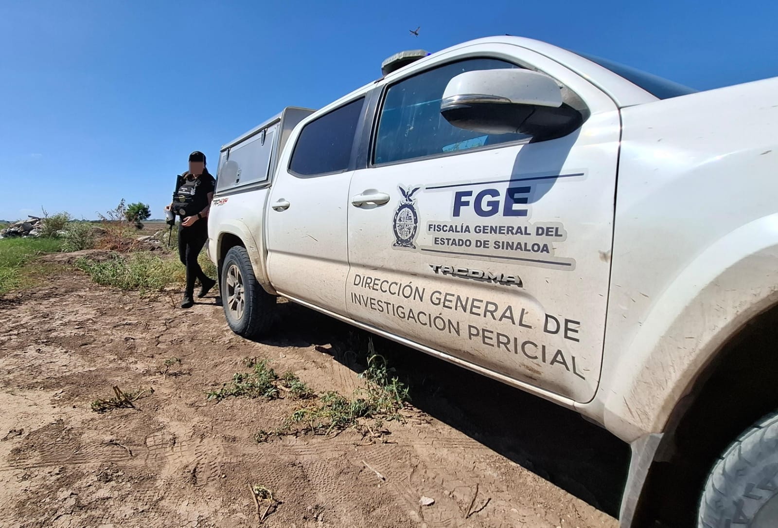 Unidad de transporte de la FGE y detrás de ella un elemento de seguridad