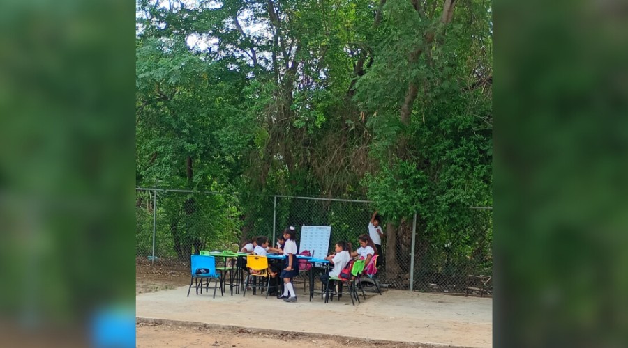 Alumnos de la primaria indigena de La Ladrillera de Mochicahui recibiendo clases afuera de las aulas por el calor