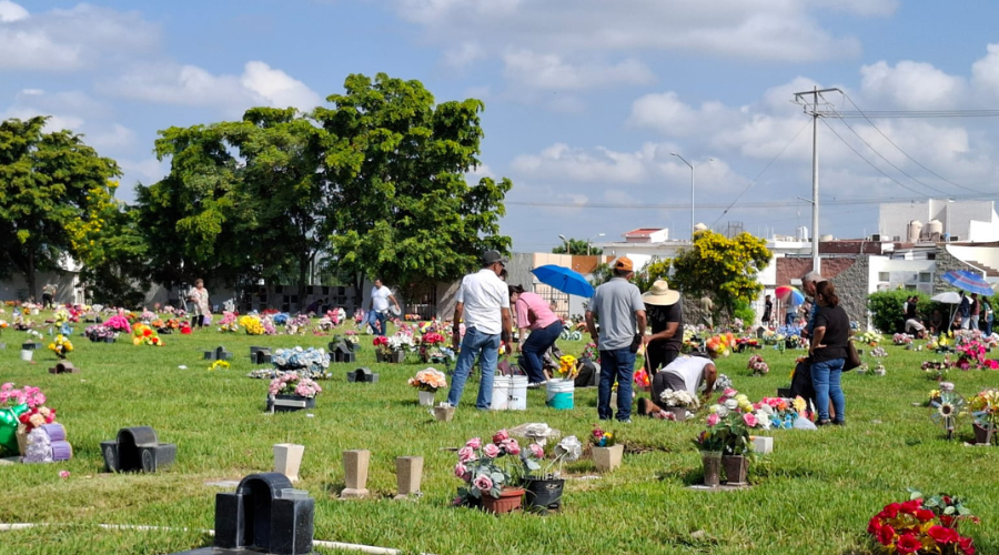 Personas vienen a limpiar las tumbas de sus difuntos