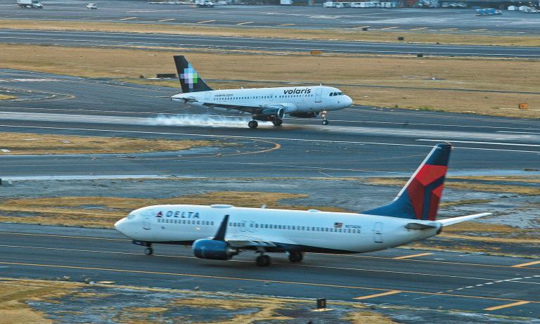 Dos aviones en un aeropuerto, uno de Volaris y otro de Delta