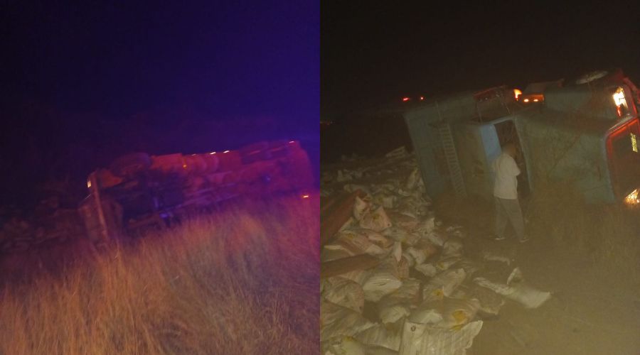 Camión de carga volteado en el asfalto con la carga derramada y una persona con playera blanca