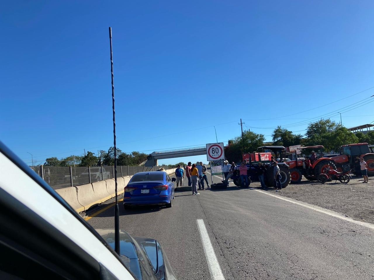 Agricultores bloquean a un costado del carril de norte a sur de la autopista Culiacán-Mazatlán, con tractores y autos