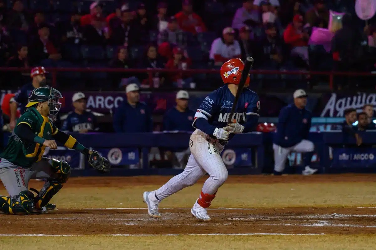 Jugador de Águilas de Mexicali en posición de correr luego de conectar un hit dentro de la caja de bateo, por detrás el cátcher de Cañeros de Los Mochis de rodillas observando la dirección de la pelota