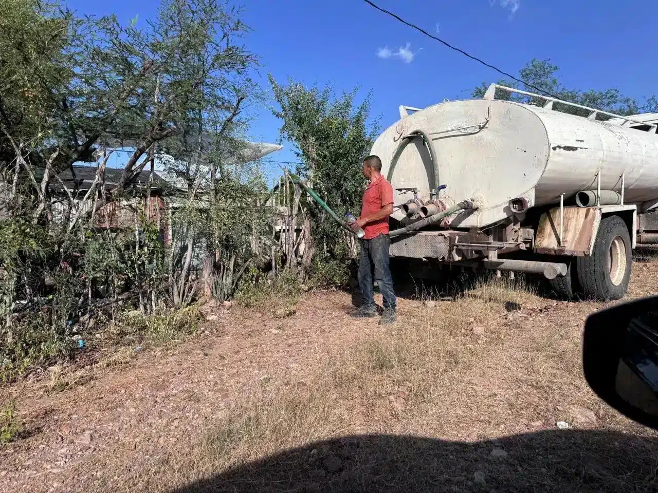 Una persona en una comunidad de El Fuerte junto a una pipa con agua
