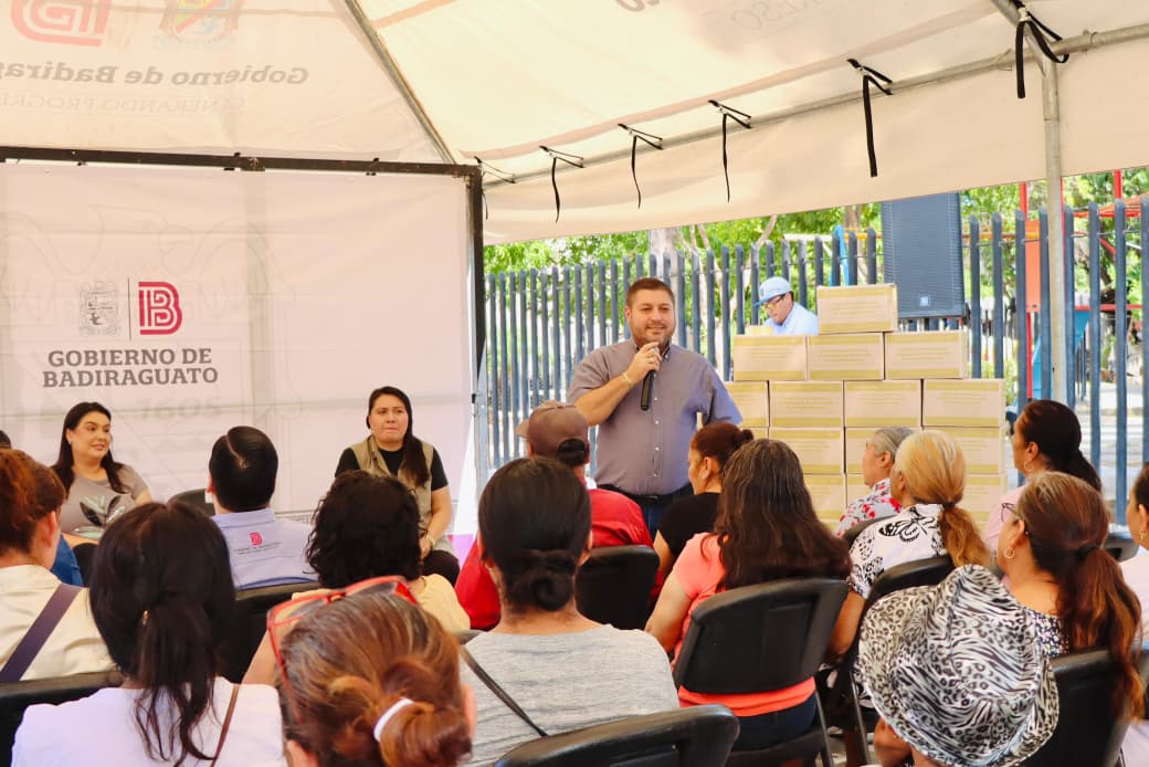 Personas sentadas en una reunión junto alcalde de Badiraguato