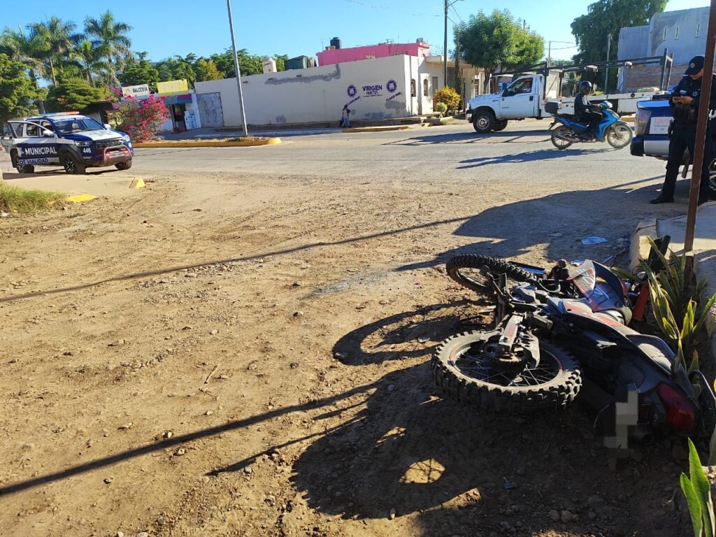 Motocicleta tirada en la calle junto a elementos de seguridad vial