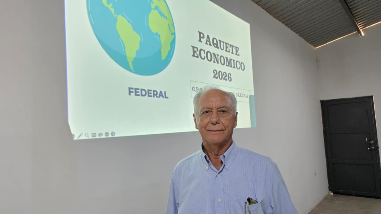 Antonio Humberto Vega Gaxiola posando para la foto y atrás una proyección