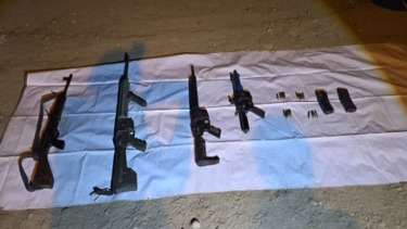 Armas aseguradas en el piso con una cobija blanca