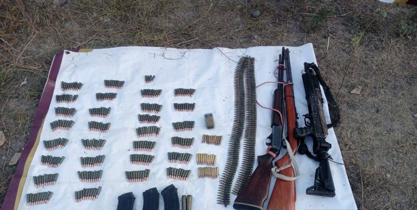 Armas y municiones en el piso junto a una sabana blanca