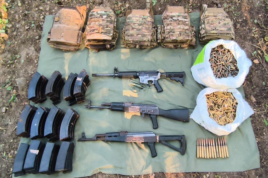 Chalecos antibalas, armas y cartuchos en el piso 