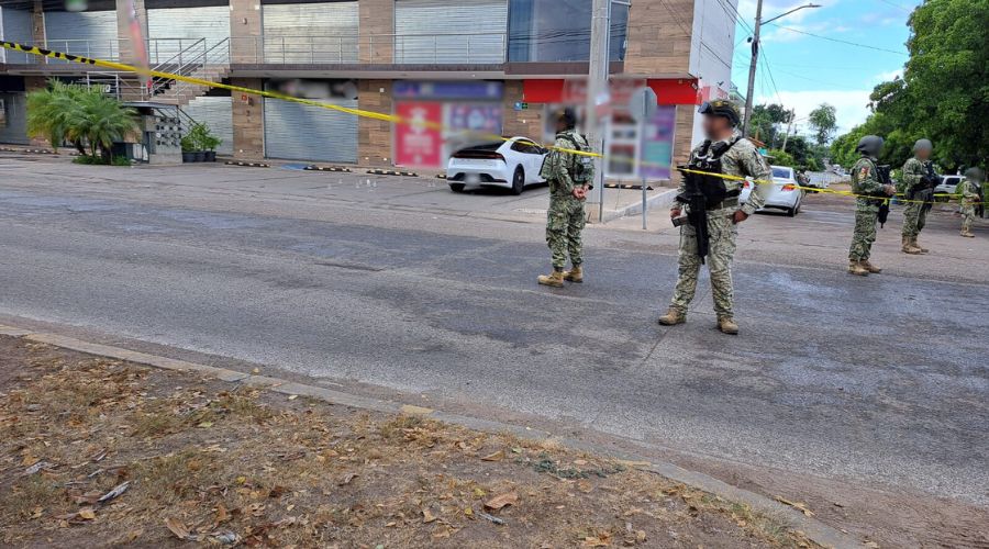 Elementos de la marina en una intersección de 2 calles en una escena del crimen, al fondo se observa el carro donde iba el conductor asesinado