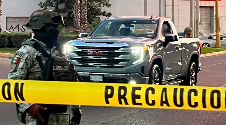 Elementos del Ejército Mexicano resguardan el área donde dos tripulantes de una camioneta fueron asesinados, en Culiacán