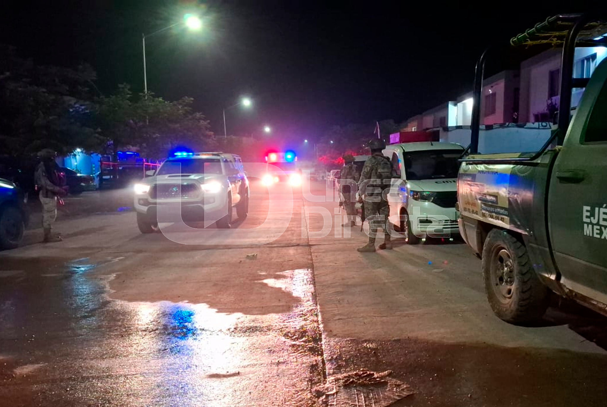 Escena de un asesinato, patrullas con luces encendidas y elementos policiacos, así como la calle mojada