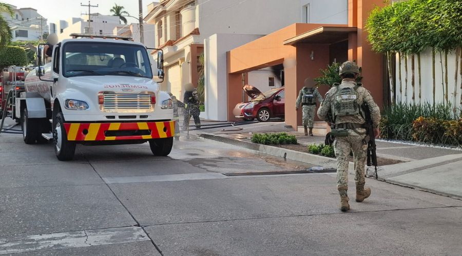 Camión de bomberos y militares en la calle, afuera de una casa que fue quemada y atacada a balazos en Culiacán