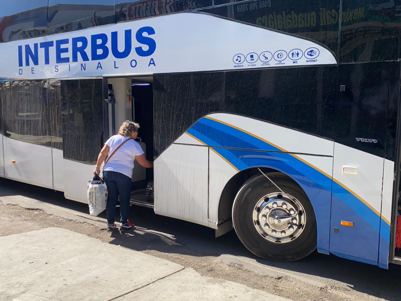 Mujer poniendo sus pertenencias en un autobús