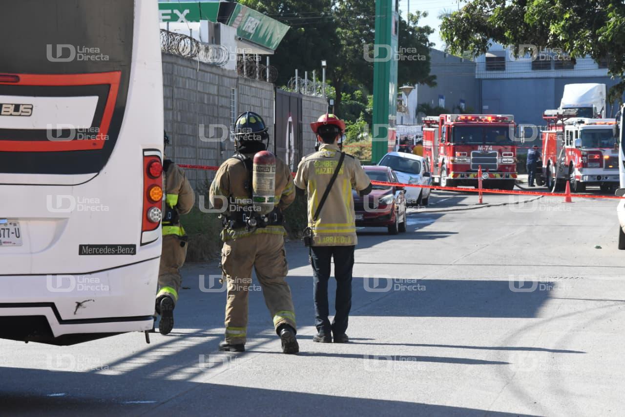 Elementos del cuerpo de bomberos caminando, al fondo se ven dos unidades de bomberos