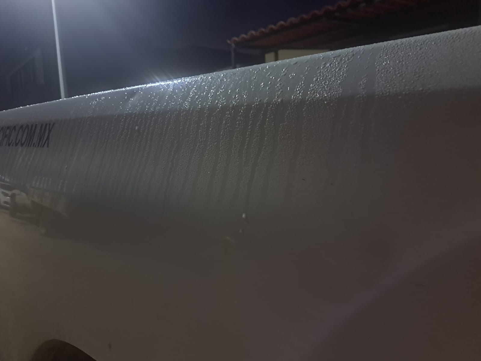Gotas de agua provocada por la brisa matutina sobre la parte trasera de una camioneta blanca