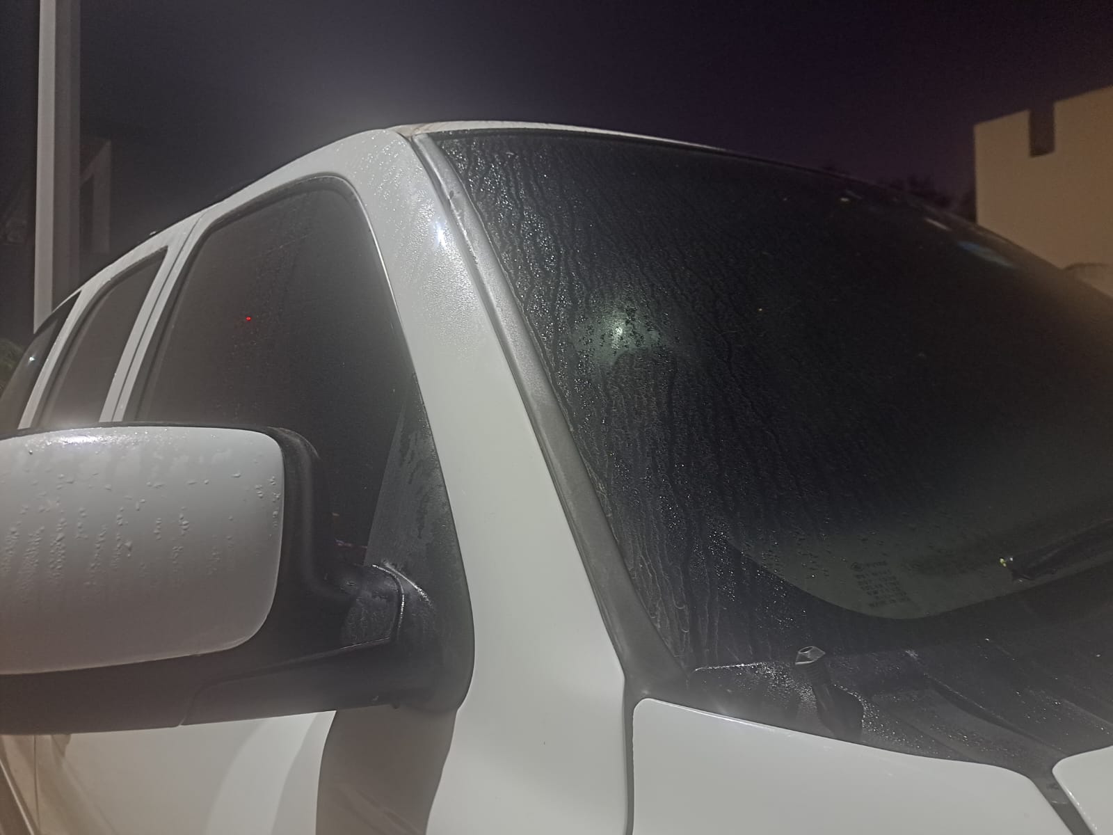 Gotas de agua provocada por la brisa matutina sobre una camioneta blanca