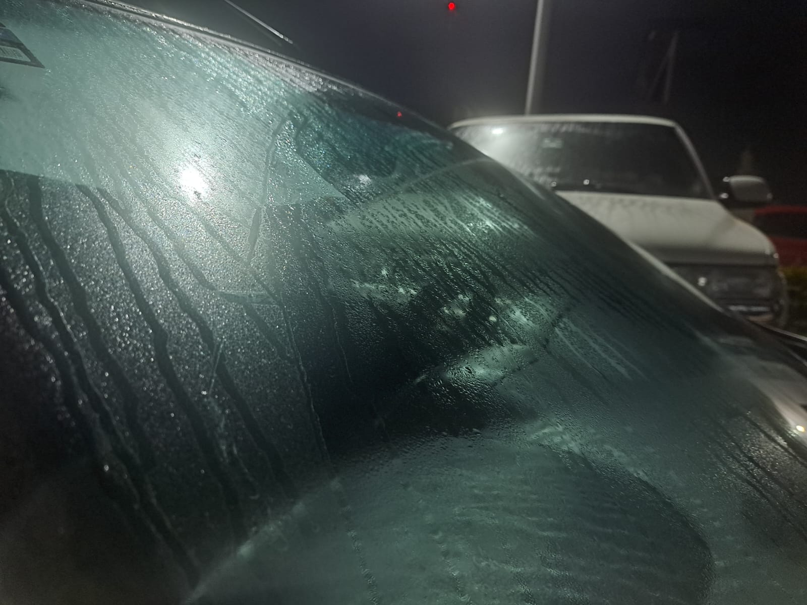 Gotas de agua provocada por la brisa matutina sobre el vidrio de un vehículo