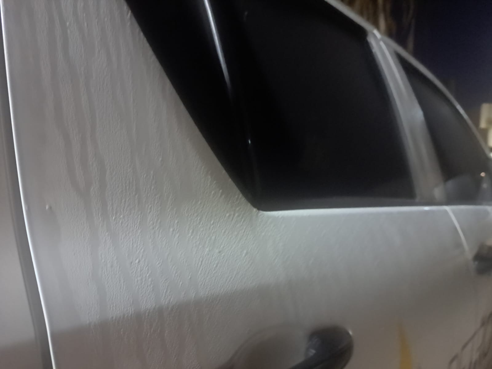Gotas de agua en la puerta de una camioneta blanca provocadas por la brisa matutina