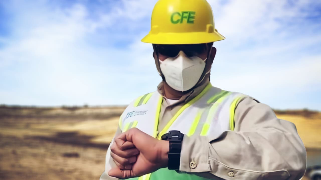 Trabajador de la CFE mirando hacia el reloj que tiene en la muñeca izquierda