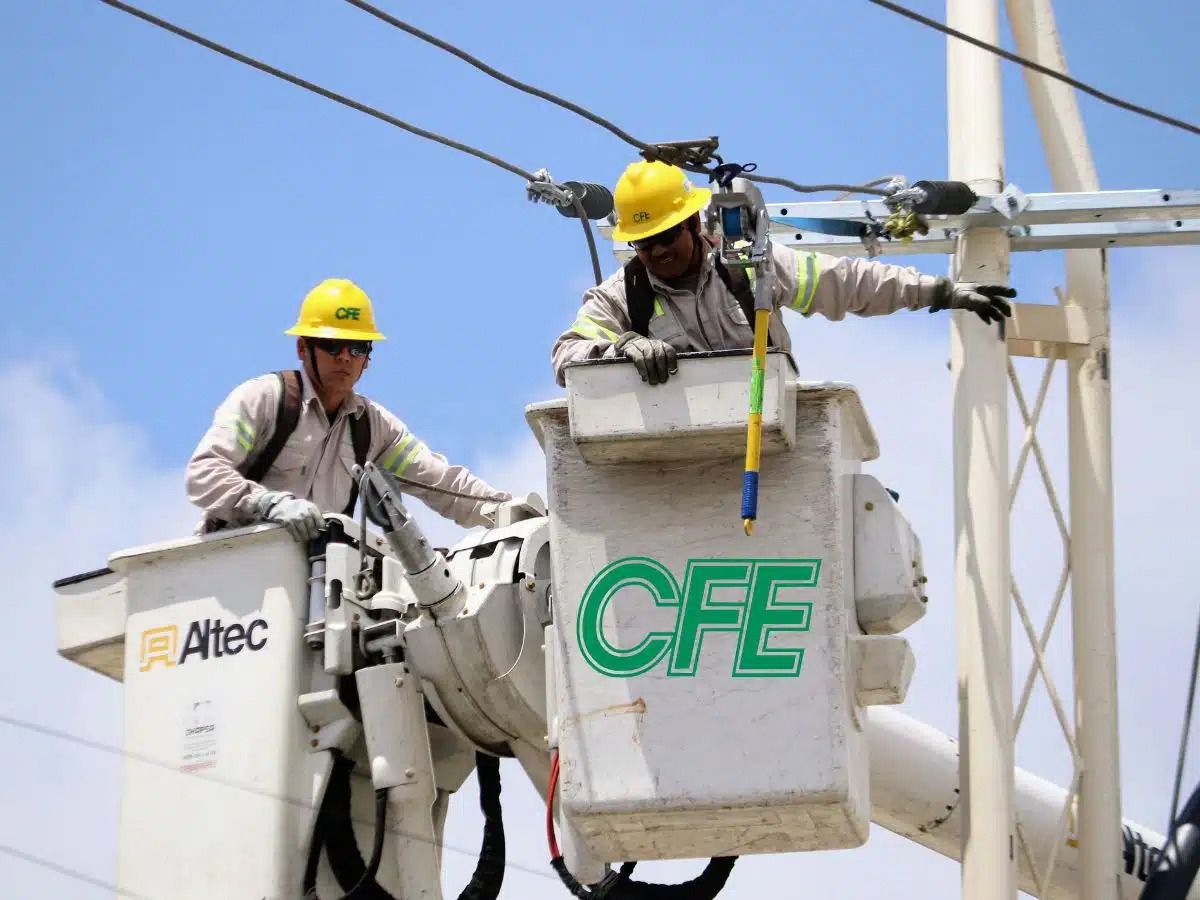 trabajdores de la CFE haciendo labores en un poste de luz