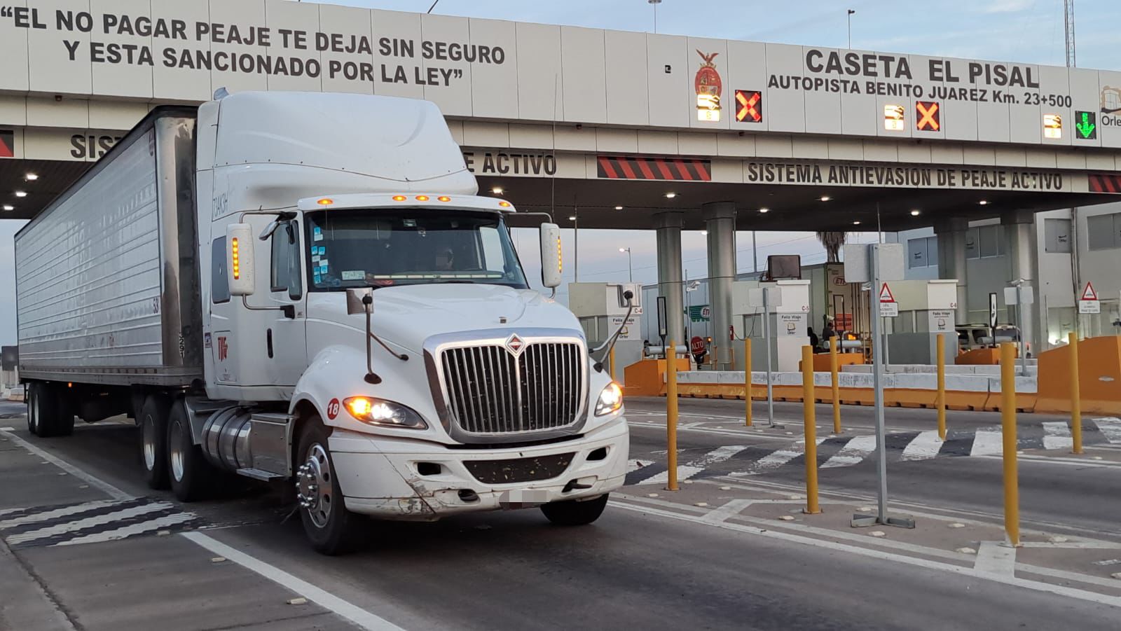 Camión de carga saliendo de una caseta de peaje