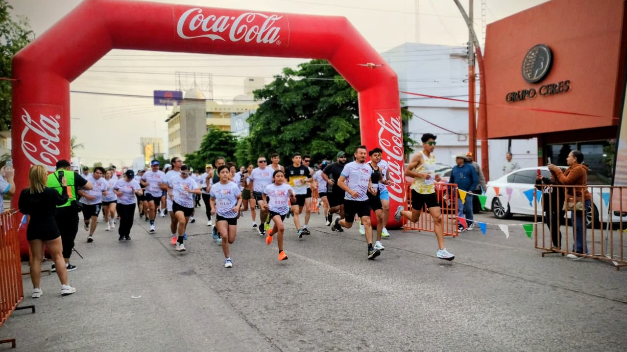 Corredores saliendo de meta en grupo y arrancando la competición