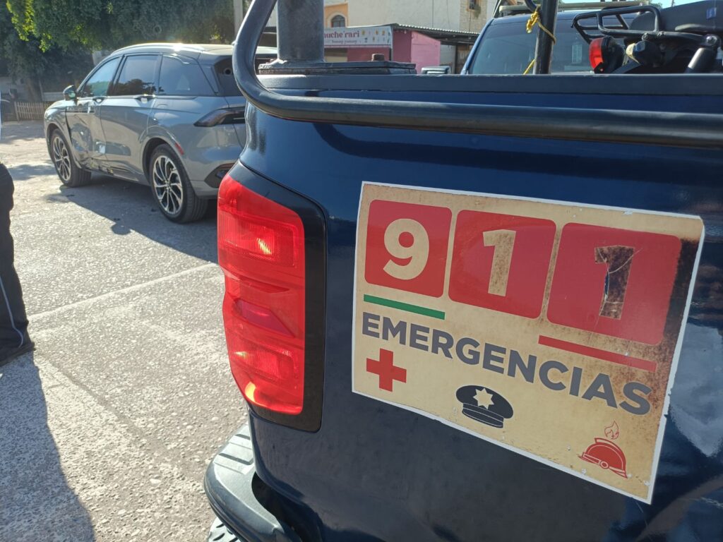 Parte trasera de una patrulla y al fondo una camioneta chocada