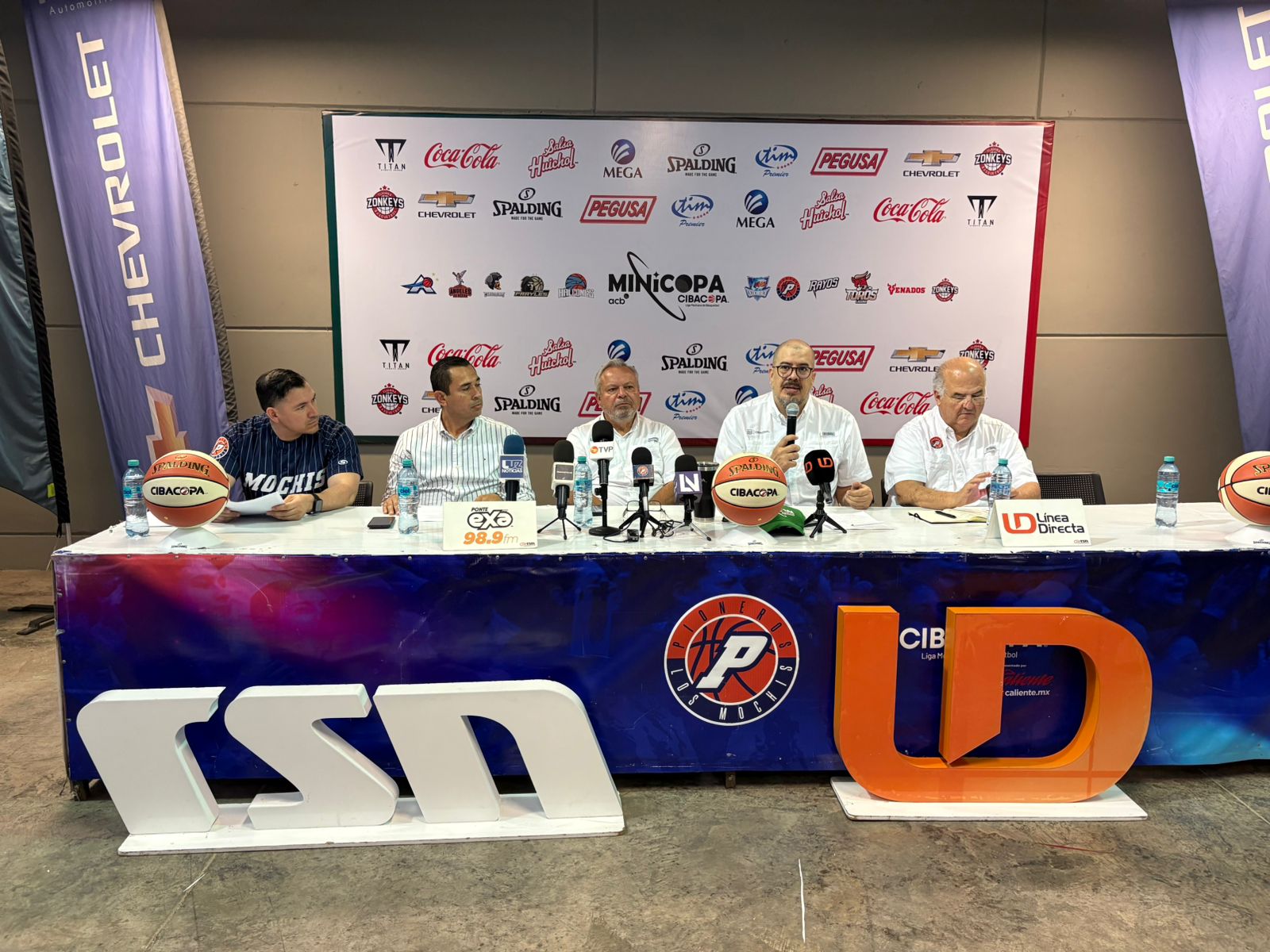 Directivos de baloncesto sentados en una mesa realizando una rueda de prensa