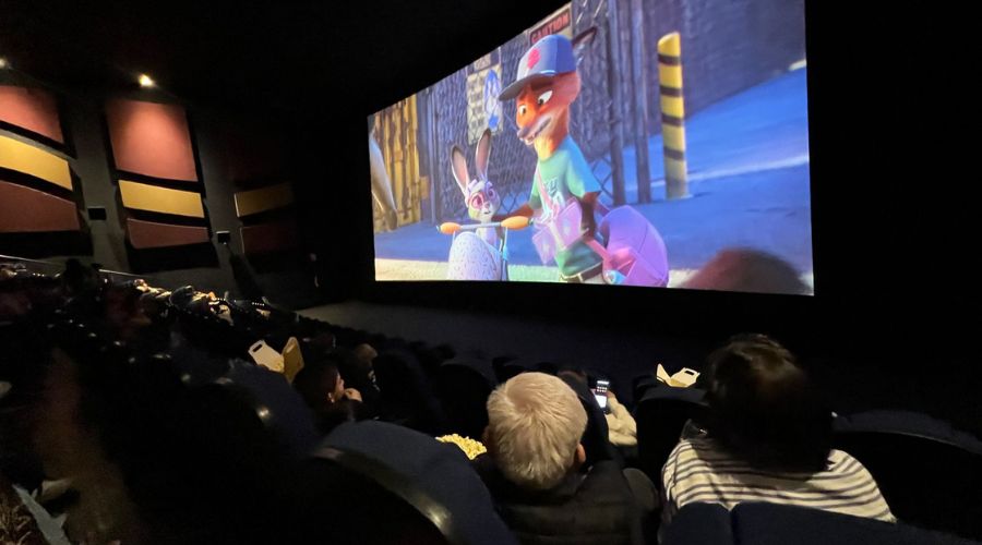 sala de cine reproduciendo una película con personas observando