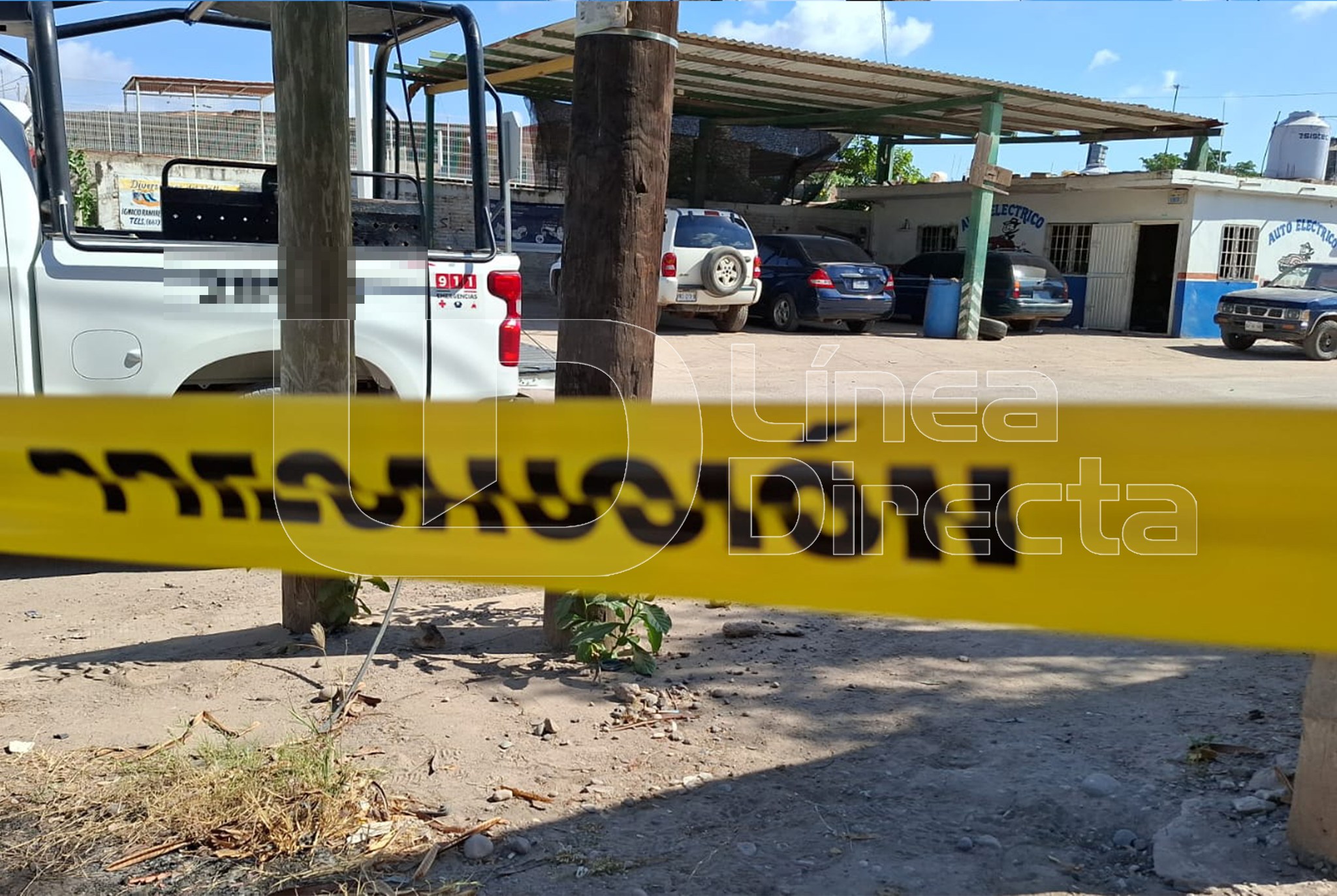 Cinta amarilla de precaución y al fondo una unidad de la Guardia Nacional