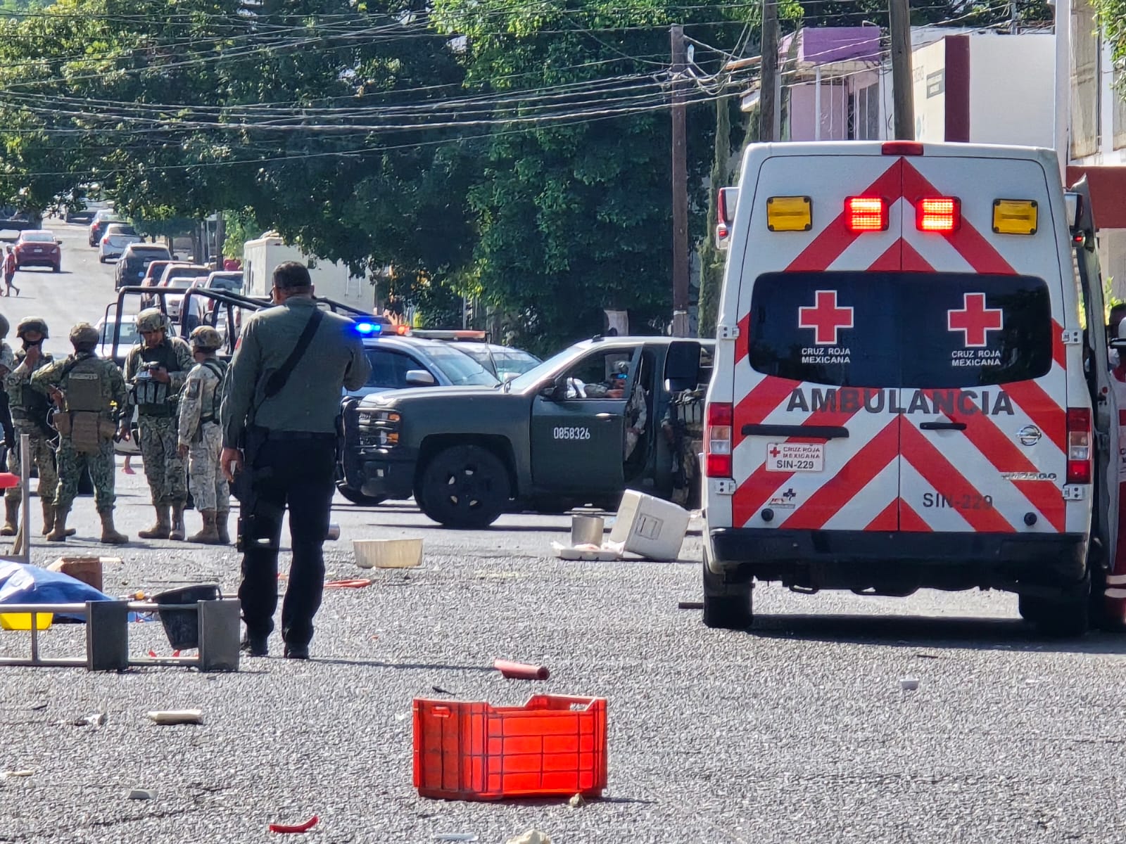 Unidades del Ejercito Nacional, Policía Municipal y Cruz Roja en la calle, donde se ven utensilios regados por la vía publica
